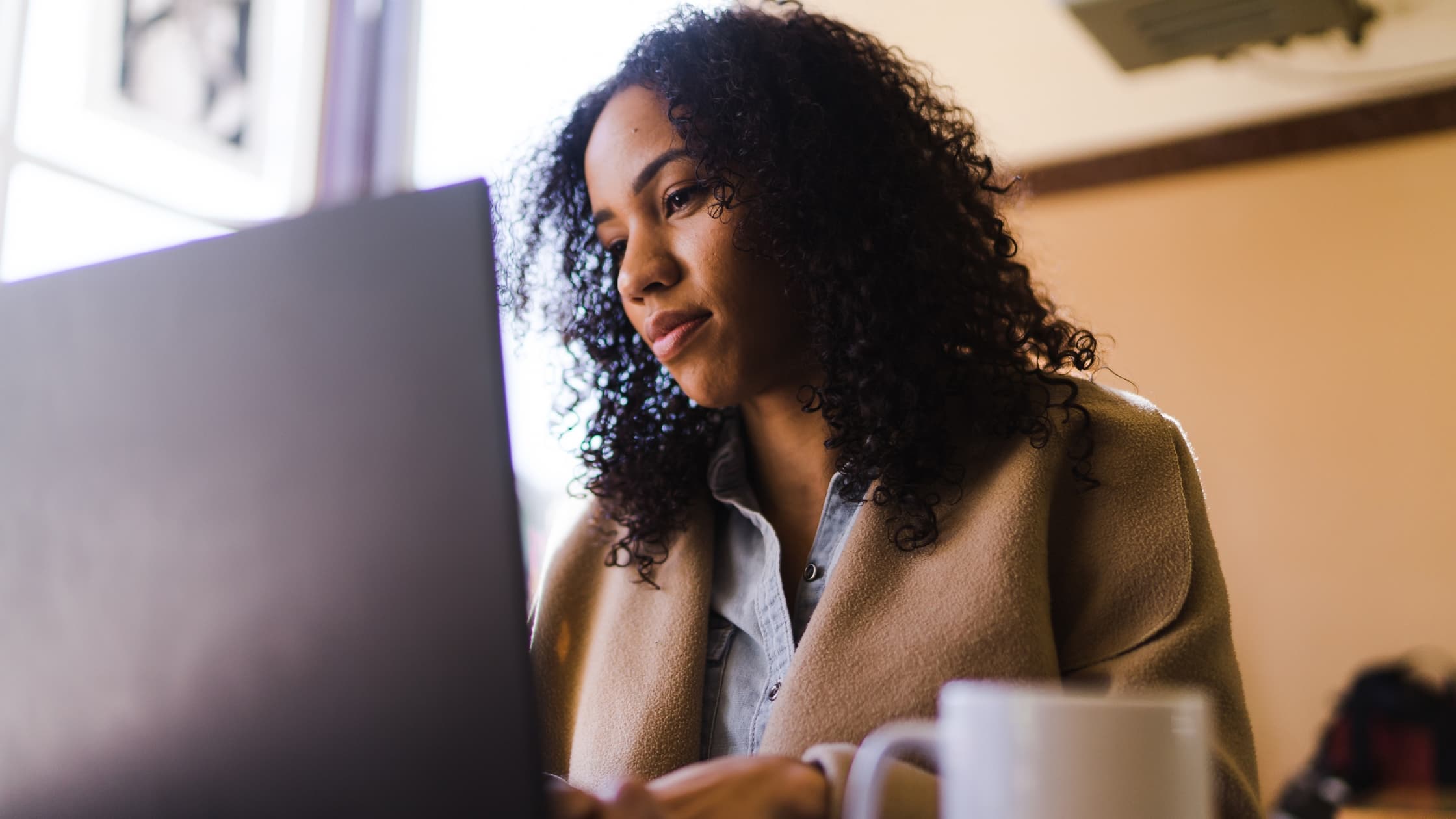 Women writing an email with P.S. at her laptop